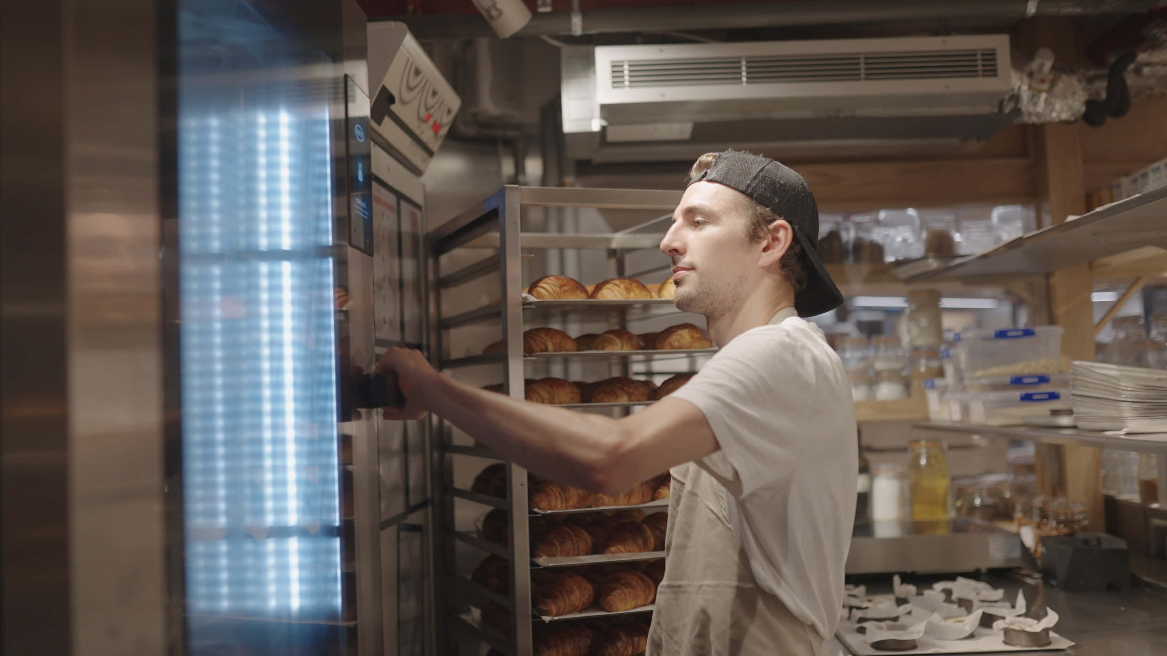 chef opening door of bakertop combi oven for bakery